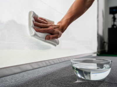 Gently cleaning a golf impact screen with a soft cloth and cool water