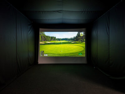 Golf simulator enclosure lined with matte blackout fabric for high contrast image