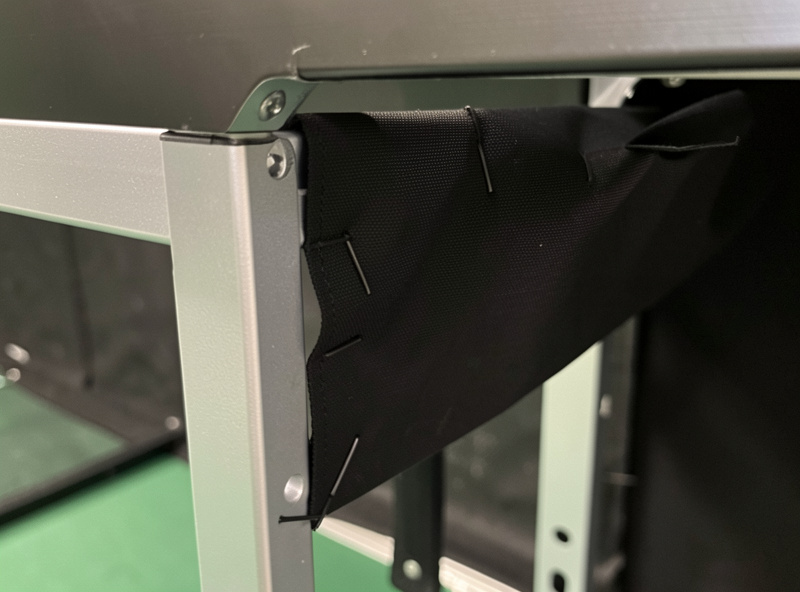 Golf simulator enclosure interior lined with matte black blackout fabric to absorb stray light