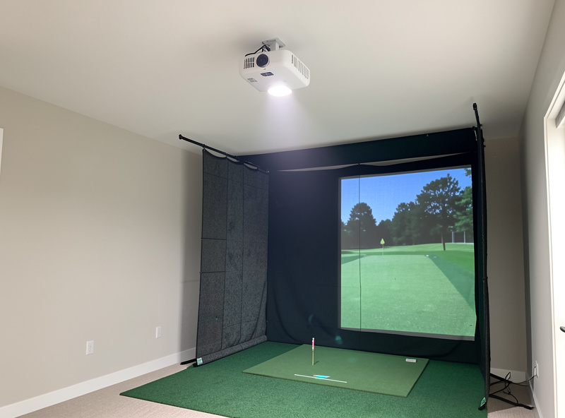 Short-throw projector ceiling-mounted forward of the hitting position in a home golf simulator enclosure