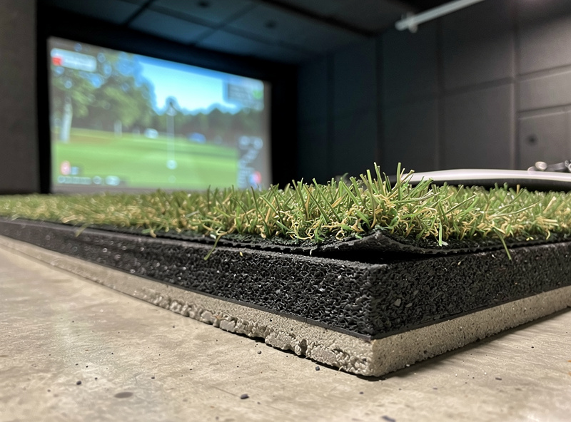 Close-up of a hitting mat and sub-floor base showing how floor build-up reduces ceiling clearance