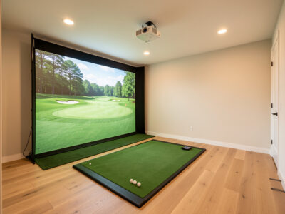 Finished mid-range home golf simulator room with impact screen and short-throw projector