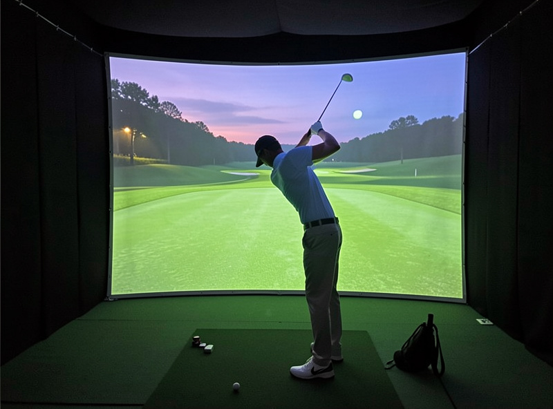 Golfer mid-swing into a bright impact screen in a home SkyTrak Plus simulator